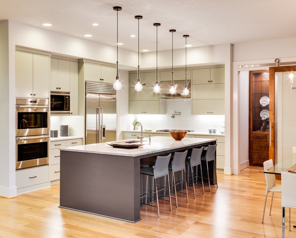 Een handenpaar dat keuken wrap aanbrengt op een keukenkastdeur, met een strakke, moderne folie in een neutrale kleur.