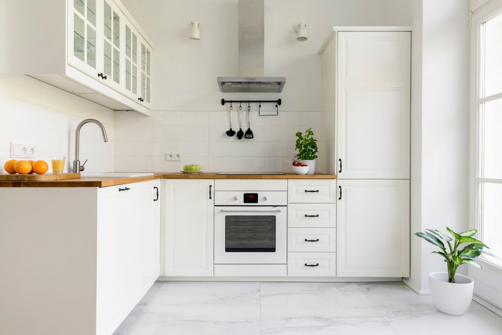 Een keuken wordt afgebeeld met vernieuwde kastdeuren na het wrappen, wat een betaalbare en stijlvolle oplossing is voor keukenrenovatie.