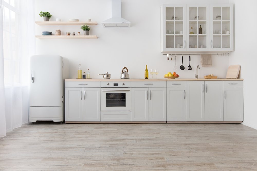 Een keuken wordt afgebeeld met keukenkastjes die zijn bekleed met folie, een betaalbare en stijlvolle oplossing voor keukenrenovatie.